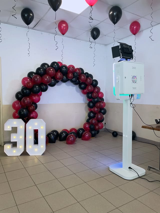 Location photobooth Marseille - installation compacte avec arche de ballons rouge et noir pour anniversaire 30 ans
